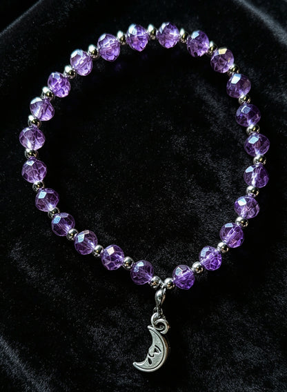 Handmade purple and silver beaded bracelet with a crescent moon pendant.